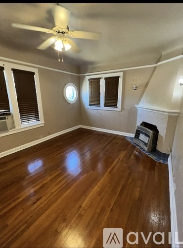 A room with wooden floors and a ceiling fan.