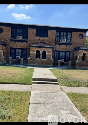A brick building with a green lawn in front.