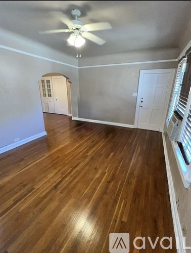 A room with wooden floors and a ceiling fan.