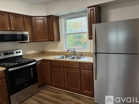 A kitchen with wooden cabinets and a stainless steel refrigerator.