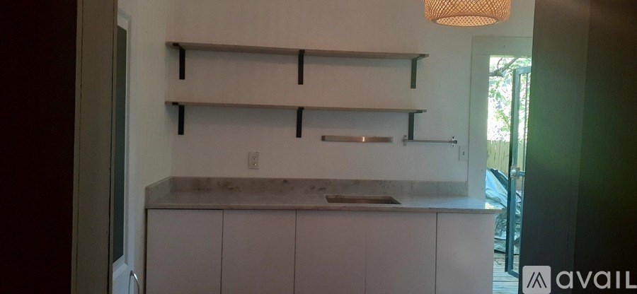 A kitchen with white cabinets and a counter top.