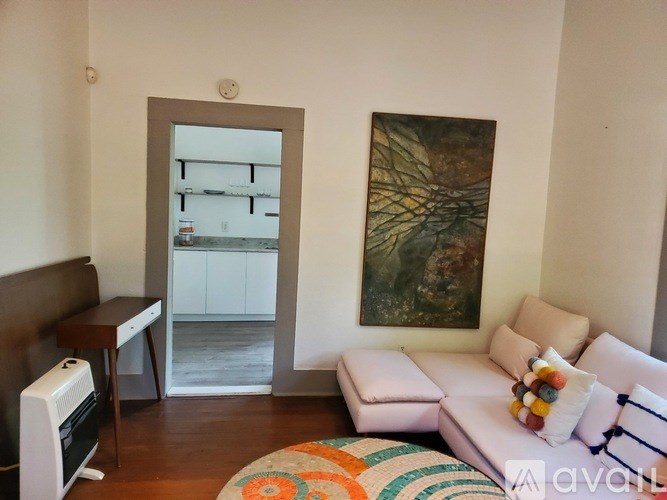 A living room with a couch, a painting, and a mirror.