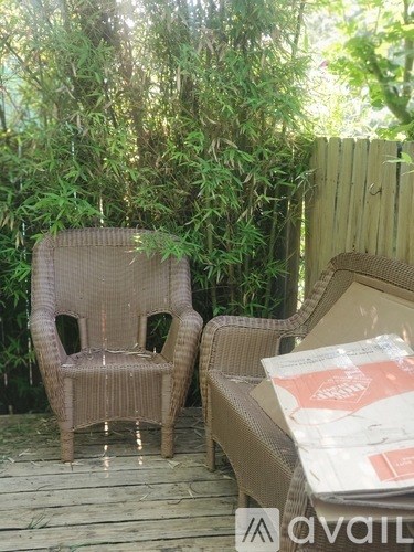 Two chairs are on a wooden deck with a package on the right.
