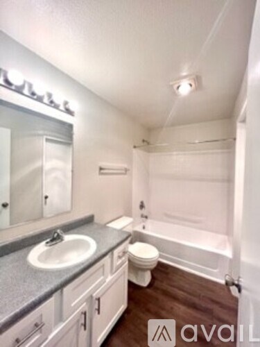 A bathroom with a sink, toilet and bathtub.