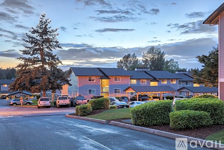 A street view of a residential area with apartment buildings and parked cars.