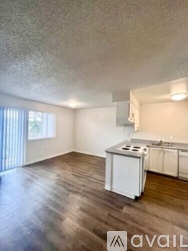 A kitchen area with a white stove and cabinets.