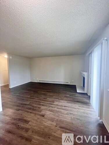 A room with wooden flooring and white walls.