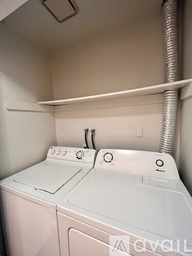 A white washing machine in a small laundry room.