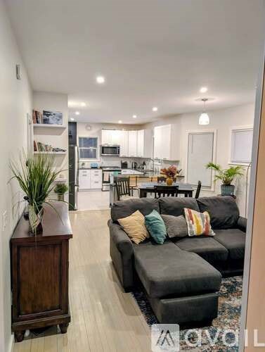 A living room with a black couch and a wooden cabinet.