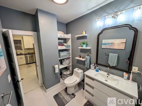 A bathroom with a toilet, sink, and mirror.