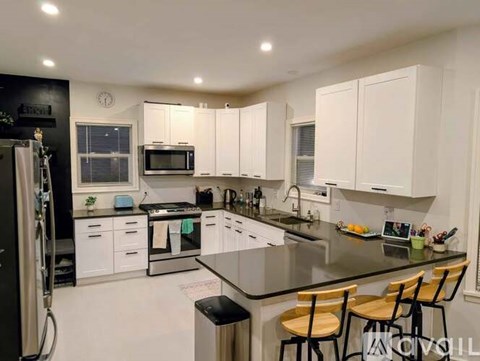 A modern kitchen with white cabinets and a black countertop.