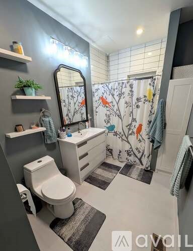 A bathroom with a toilet, sink, and a mirror.