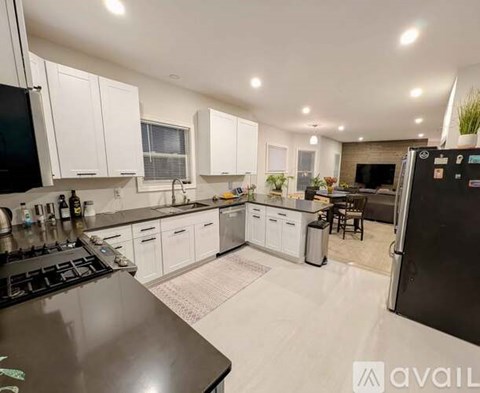 A kitchen with white cabinets and a black stove top.