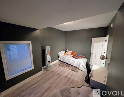 A bedroom with a bed, nightstand, and window.