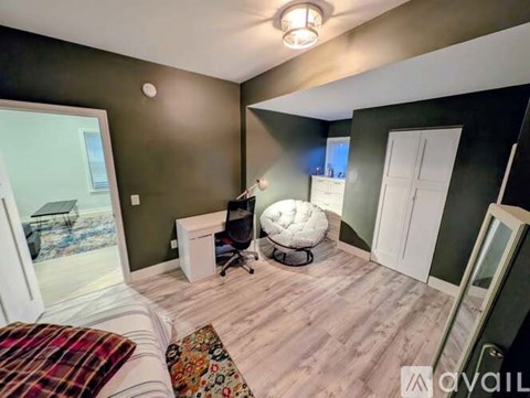 A room with a bed, a chair, and a desk.