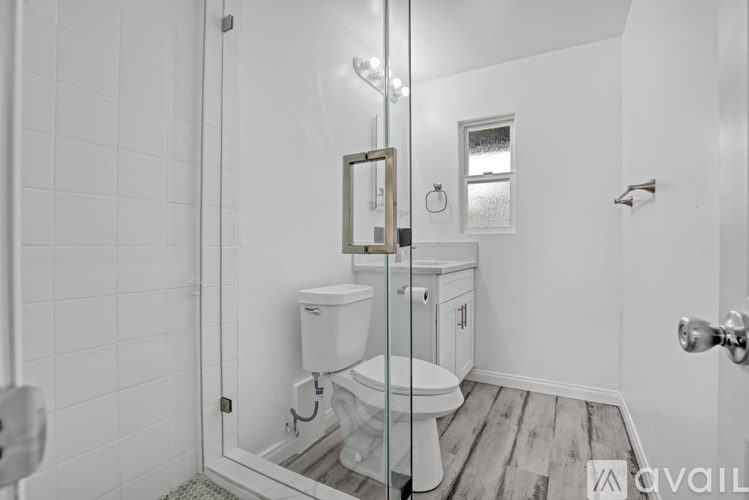 A white tiled bathroom with a toilet and sink.