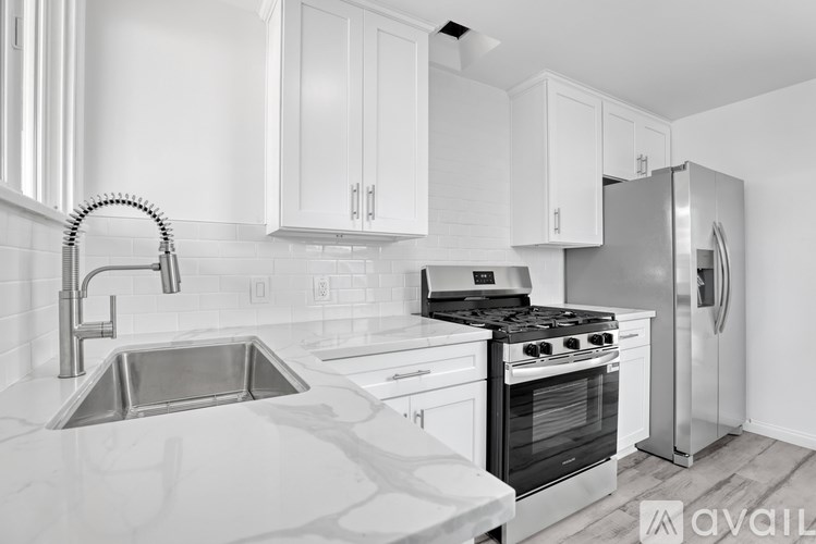A modern kitchen with white cabinets and stainless steel appliances.