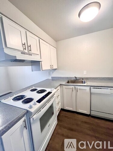 A kitchen with white cabinets and a stove top oven.