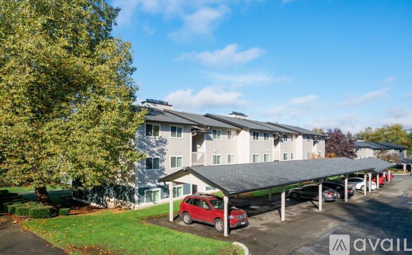A carport with a red car parked in front of a building.