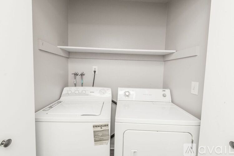 Two white front loading washing machines in a small laundry room.