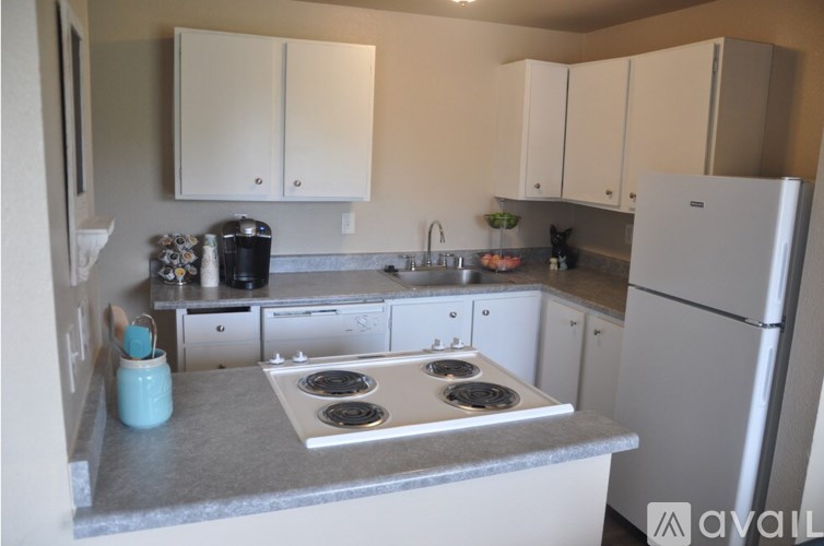 A kitchen with white cabinets and a stove top oven.