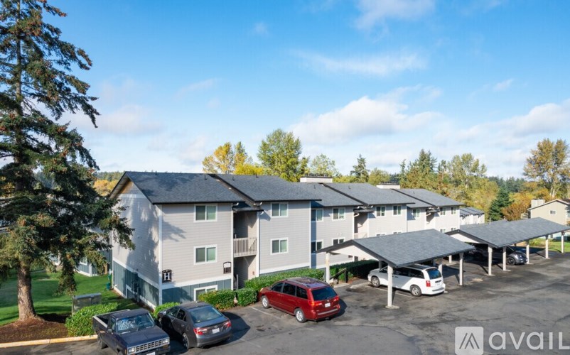 A parking lot in front of a building with cars parked.