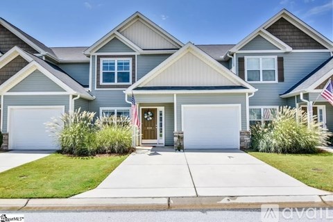 A two-story house with a garage and a front yard.