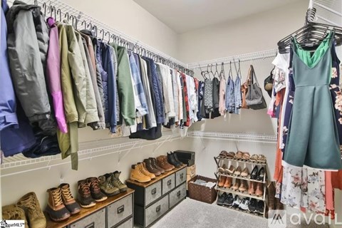 A well-organized walk-in closet with clothes and shoes neatly arranged.