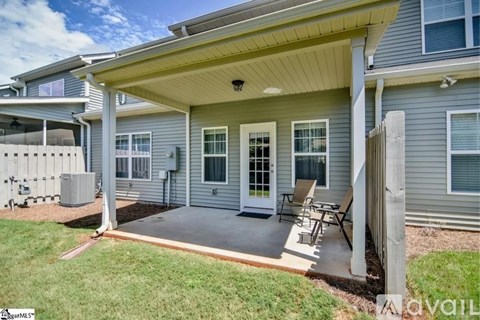 A house with a covered patio and a white fence.