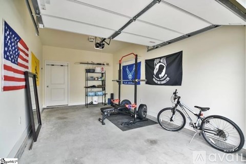 A garage with a bicycle, a treadmill, and a flag hanging on the wall.