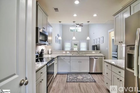 A kitchen with a white countertop and stainless steel appliances.