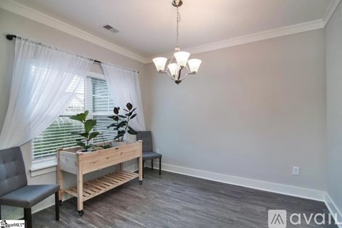 A room with a wooden bench and a grey chair.