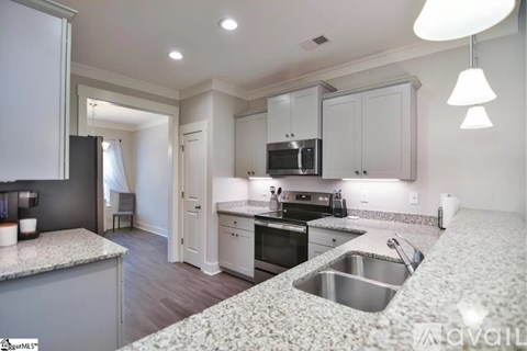 A kitchen with a granite countertop and stainless steel appliances.