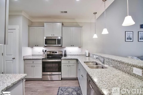 A kitchen with granite countertops and stainless steel appliances.