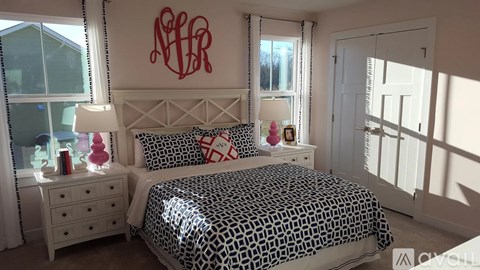 A bedroom with a leopard print bed and a monogrammed wall.