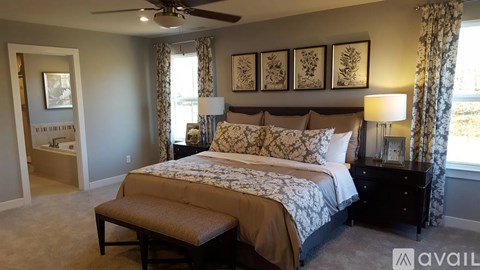 A bedroom with a large bed and a ceiling fan.