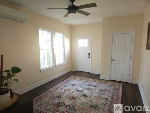 A room with a rug on the floor and a ceiling fan.
