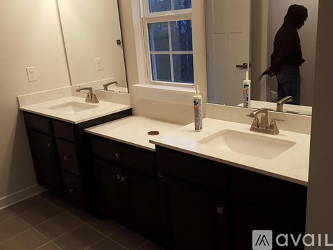A bathroom with two sinks and a large mirror.