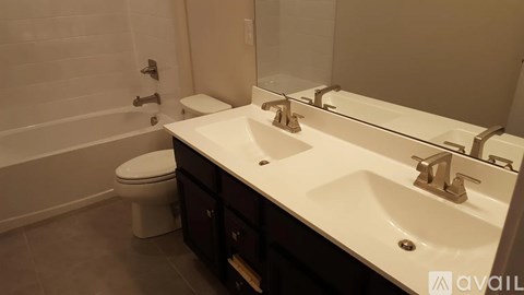 A white toilet sits next to a white sink in a bathroom.
