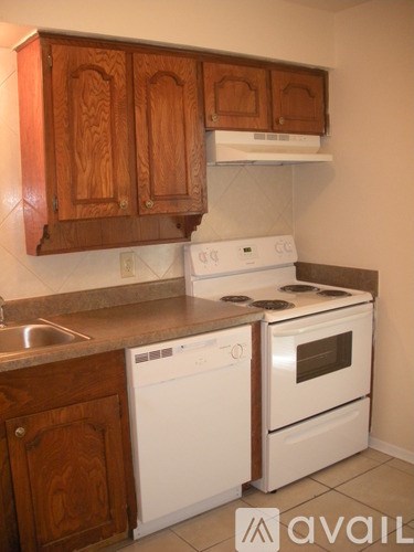 A kitchen with wooden cabinets and white appliances.