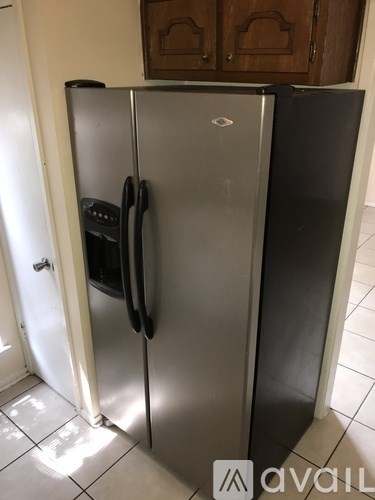 A black fridge with a white fridge next to it.