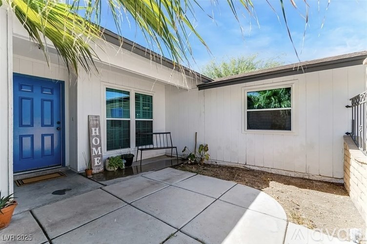 A house with a blue door and a sign that says "HOME".