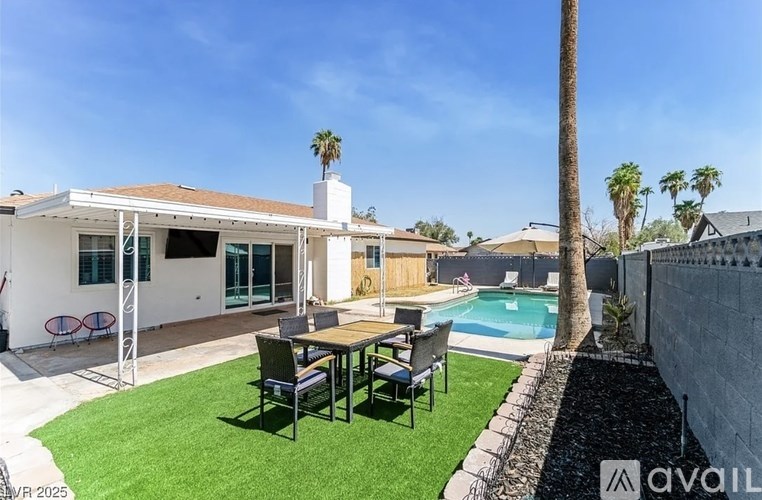 A house with a pool and a backyard with a table and chairs.