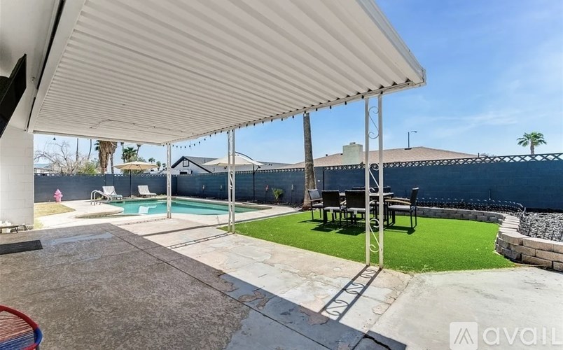 A patio with a table and chairs under a roof.