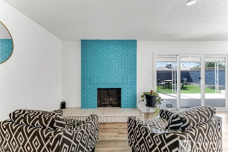 A living room with a fireplace and two patterned sofas.