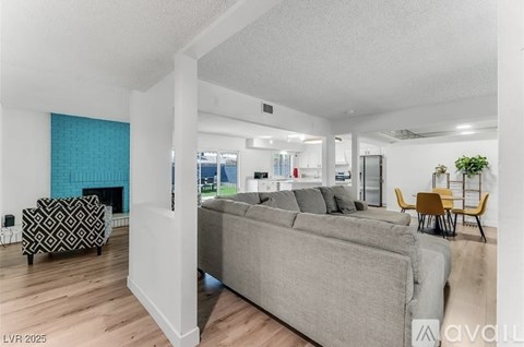 A living room with a grey couch and a black and white patterned chair.