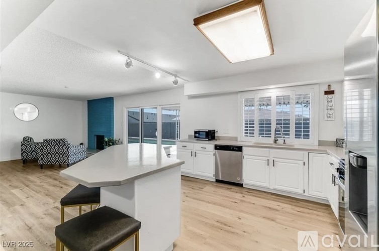 A kitchen with a white island and a black and white patterned sofa.