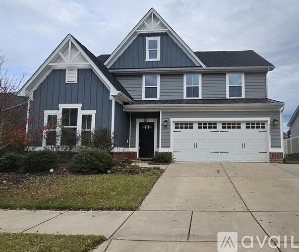 A two-story house with a garage and a driveway.