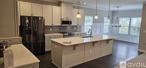 A kitchen with a refrigerator, microwave, and stove.