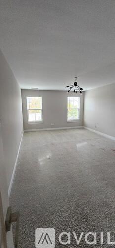 A room with a carpeted floor and a ceiling fan.